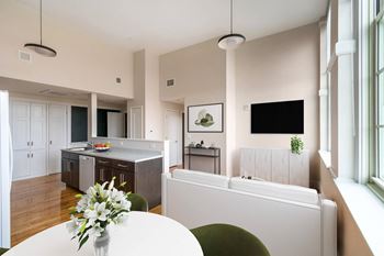 A kitchen and dining room with a white table and chairs